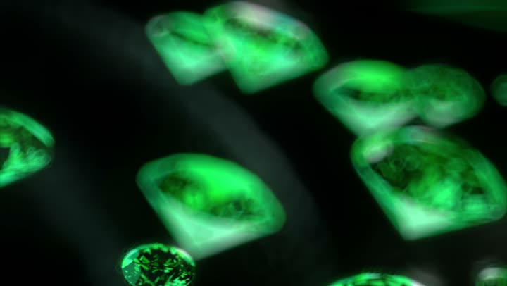 Cut emeralds drifting in the green water.